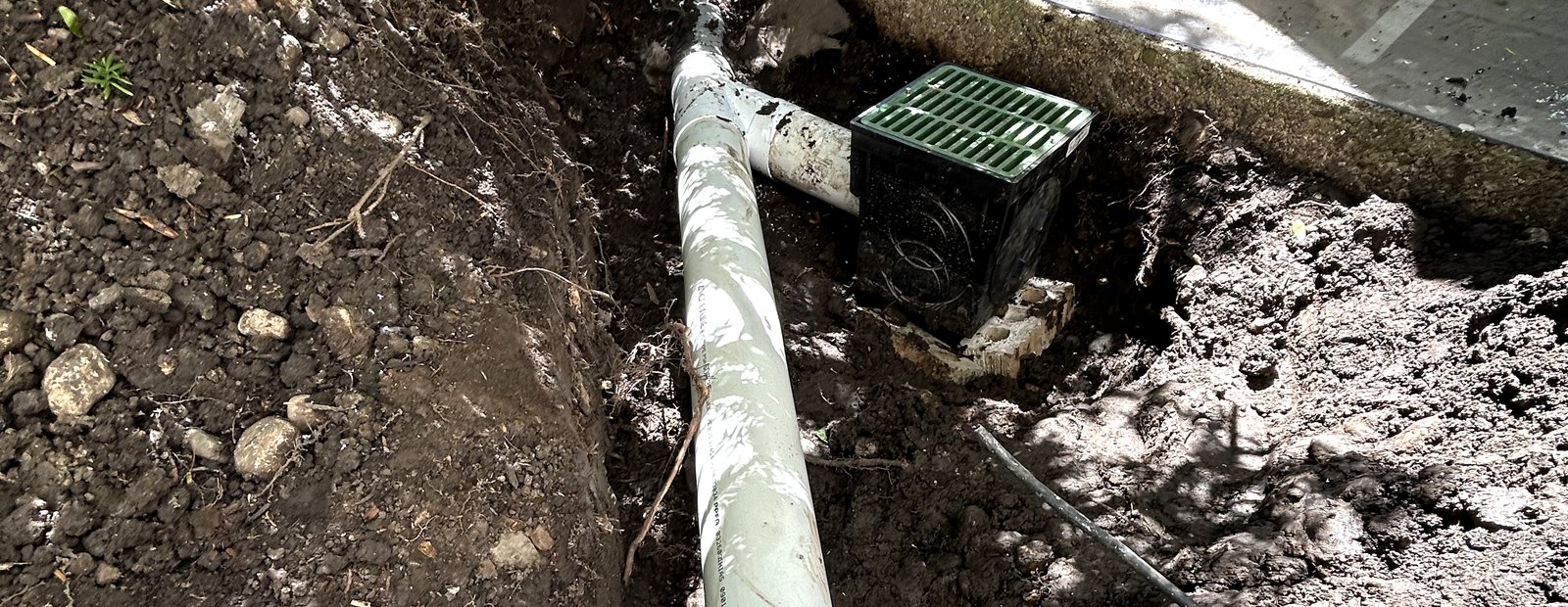 RV Landscaping drainage system installation — catch basin and PVC drain line